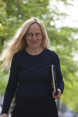  Business woman walking with her laptop outdoors