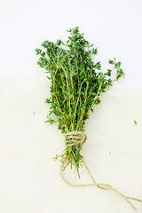 Bunch of fresh thyme leaves tied with string on white background