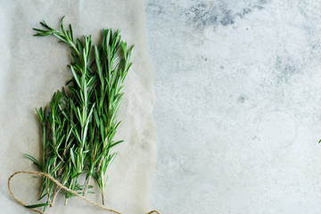 Flatlay with rosemary sprigs arranged on metallic background with text space