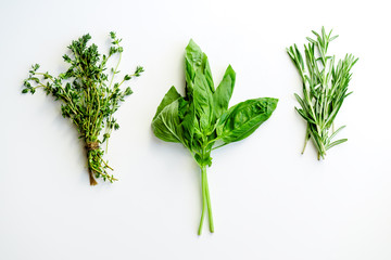 Rosemary, basil and thyme herbs on white background