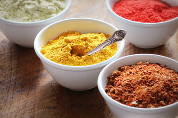 Various colorful spices on wooden table in bowls . Food and cuisine ingredients.