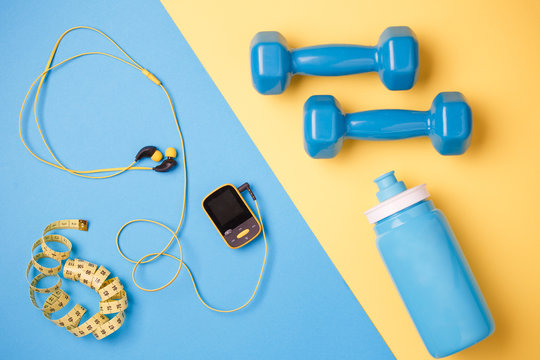 Photo of player, dumbbells, bottle of water, centimeter tape on blue and yellow background