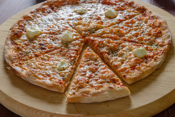Pizza on wooden board sliced