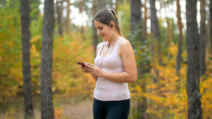 Portrait of young woman in sporty clothes using smartphone