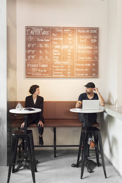 Man and woman with laptop in cafe