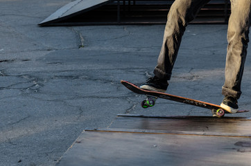 Legs of the skater on skateboard in skatepark