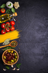 Selection of healthy food. Italian food background with spaghetti, mozzarella parmesan cheese, olives, tomatoes and rosemary. Vegetarian food banner. overhead, vertical