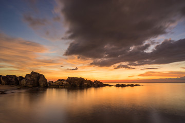 Amazing colorful sunset with clouds on sky and rocks in water on Phu Quoc Island in Vietnam