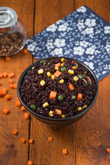 Diet fried Black rice with snap peas and vegetables on a background wood

