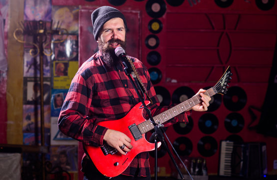 Musician with beard play electric guitar instrument. Frontman concept.