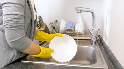 Closeup photo of young housewife washing big bowl in kitchen sink