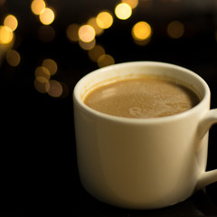a cup of coffee on the blurred background of led lights 