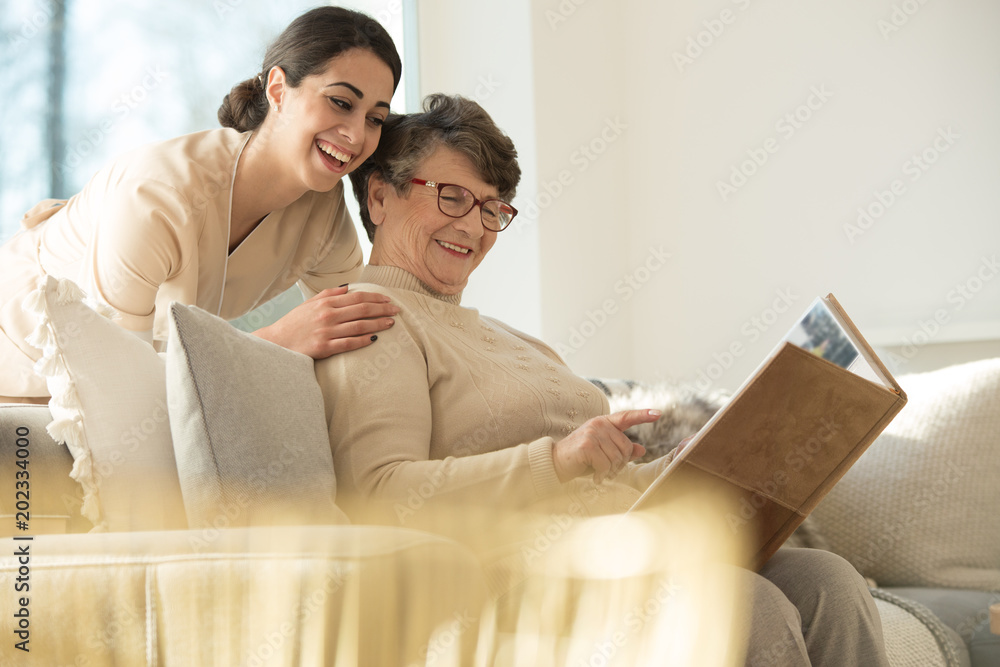 Sticker happy elderly woman watching photobook