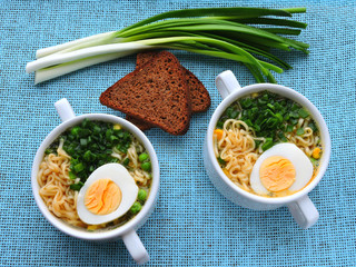 Noodle soup in a white bowl with egg and green onion