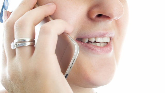 Closeup image of female lips talking by mobile phone