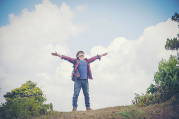 Freedom traveler Young man standing with raised arms and enjoying a beautiful nature.