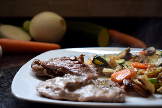 Carne Frita Con Verduras En Un Plato Y Verduras Crudas Sobre Un Fondo Negro