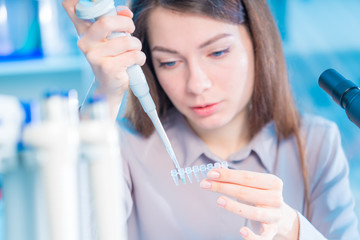 Young woman cutting of sample from pcr microtube rack