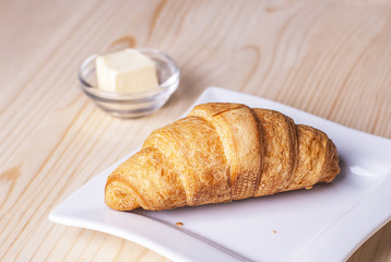 croissant on the table, next to butter and corn