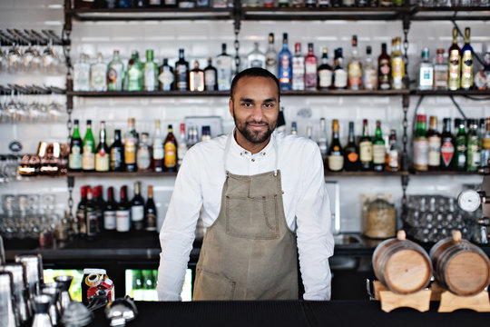 Portrait of man standing behind bar