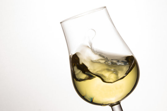 Wave Of White Wine In A Tilted Glass