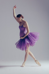 Young beautiful ballerina is posing in studio