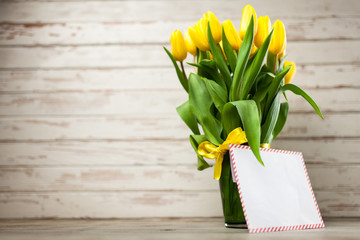 Yellow tulips on wooden background
