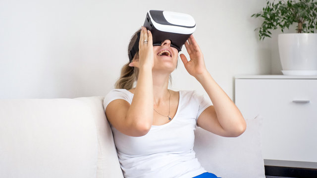Portrait of excited young woman in VR headset looking around herself