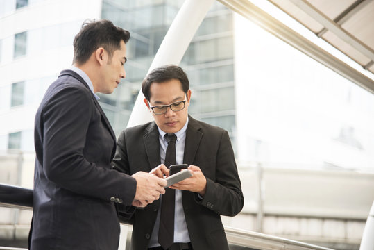 Businessman partner discussing with mobile phone.