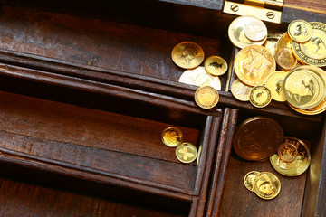 Bunch of modern gold coins in wooden casket