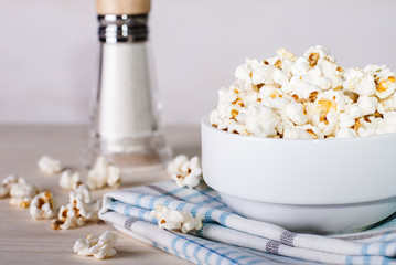 popcorn in a white bowl on a table with ingredients
