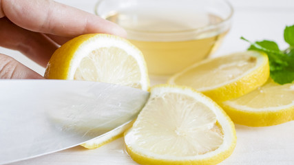 Macro image of fresh lemon being cut with sharp knife