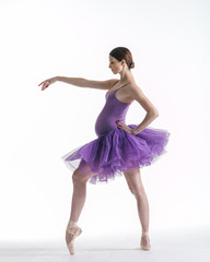 Young beautiful ballerina is posing in studio