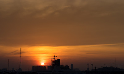 sunset time with golden hour sky and cityscape silhouette