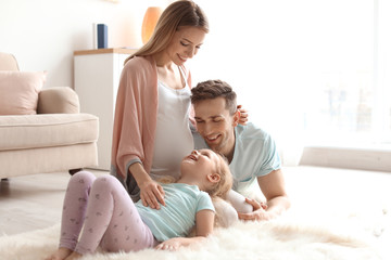 Fototapeta premium Young pregnant woman with her family at home