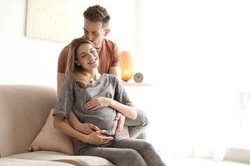 Young pregnant woman with her husband at home