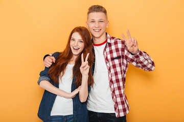 Portrait of a happy teenage couple showing peace