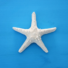 vacation and summer image with starfish over blue wooden background.