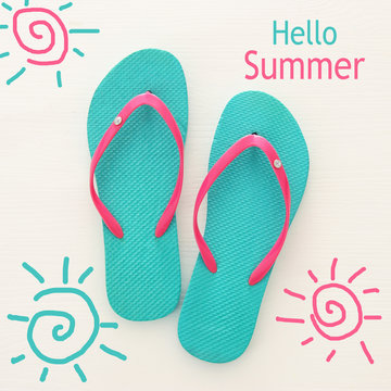 vacation and summer image with flipflops over white wooden background.