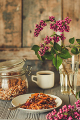 Organic granola and flowers on a wooden table.  Food background