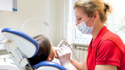 Closeup portrait of pediatric dentist treating girls teeth