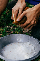 Man shredding coconut into coconut flake