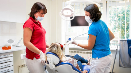 Dentist adjusting special UV lamp for teeth whitening