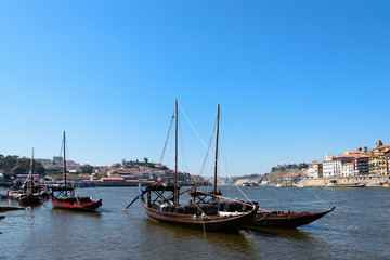 Fototapeta na wymiar Wine transport boats in Portugal. These boats transport the barrels of wine from the interior of the country to Vila Nova de Gaia and Porto.