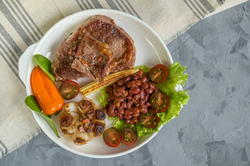 Rare steak with blood pepper garlic tomatoes broccoli grilled on a slate plate