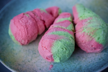 Obraz na płótnie Canvas Bright pink-green ice cream on colorful plate.
