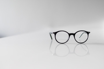 Black Eyeglasses closeup. Eye glasses.Modern style eyeglasses. Round glasses with transparent lenses. Vintage Glasses on white background. Close up eyeglasses with blurry technique.Fashion accessories