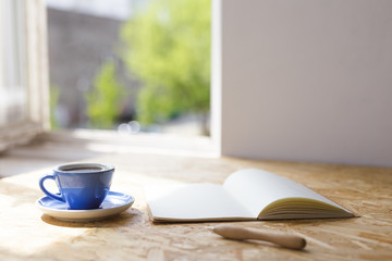 Close up on notebook and coffee cup.