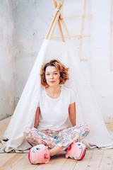 Woman in her pyjamas sitting on the floor in handmade wigwam © different_nata