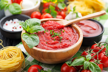 Ingredients for cooking - tomato sauce, pasta, tomatoes, garlic, olive oil on the old wooden background. top view.